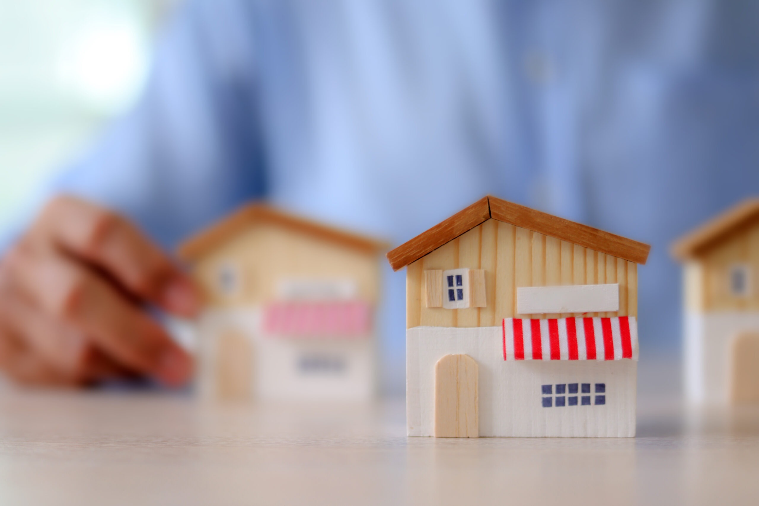 Businessman's hand chooses wooden toy franchise store